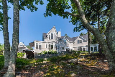 Example of a mid-sized transitional gray two-story wood exterior home design in Portland Maine with a shingle roof