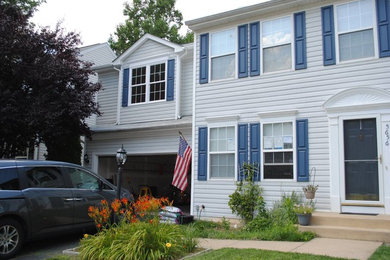 Example of a large white two-story wood flat roof design in DC Metro