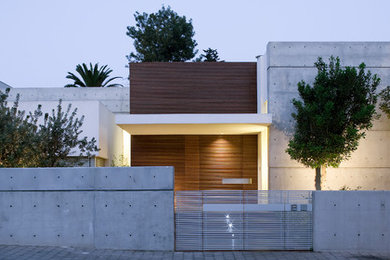 This is an example of a large modern two-storey concrete grey house exterior in Other with a flat roof.