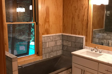 Drop-in bathtub - mid-sized rustic master gray tile and marble tile light wood floor and beige floor drop-in bathtub idea in Other with shaker cabinets, white cabinets, brown walls, an undermount sink, marble countertops and gray countertops