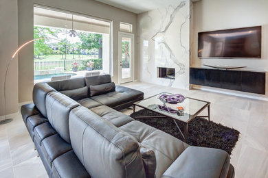 Living room - large contemporary formal and open concept gray floor and porcelain tile living room idea in Houston with beige walls, a standard fireplace, a stone fireplace and a wall-mounted tv