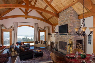 Living room - large rustic open concept dark wood floor living room idea in Portland Maine with a standard fireplace, a stone fireplace, a wall-mounted tv and white walls