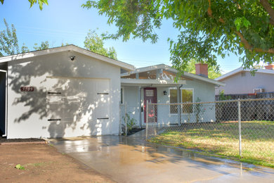 Large minimalist blue one-story stucco exterior home photo in Sacramento with a shingle roof