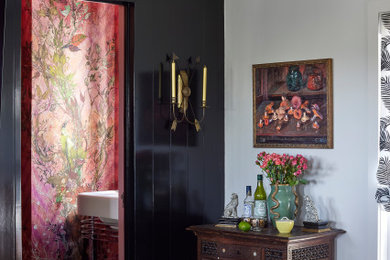 Example of a mid-sized tuscan dark wood floor and wall paneling family room design in Los Angeles with black walls