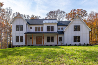 Modelo de fachada de casa blanca y negra grande con tejado de varios materiales
