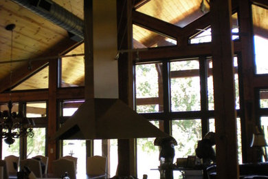 Inspiration for a huge rustic u-shaped concrete floor open concept kitchen remodel in Little Rock with a drop-in sink, dark wood cabinets, stainless steel appliances, two islands, flat-panel cabinets and solid surface countertops