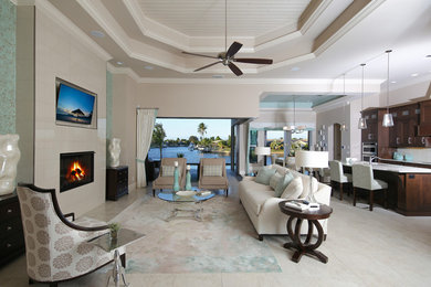 Example of a large trendy open concept and formal ceramic tile and beige floor living room design in Miami with gray walls, a standard fireplace, a wall-mounted tv and a tile fireplace