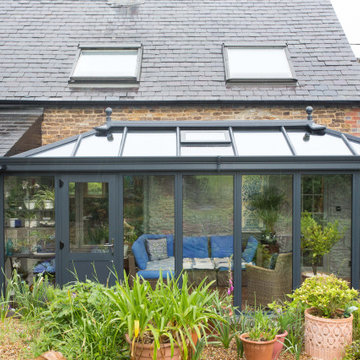 Modern charcoal aluminium framed orangery extension on a stone and timber clad c
