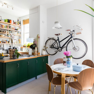 Ejemplo de cocina comedor en U, escandinava, pequeña, con armarios estilo shaker, puertas de armario verdes, encimera de madera, península y suelo beige