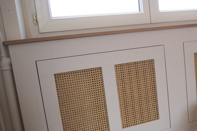 Modelo de salón cerrado y beige y blanco clásico renovado de tamaño medio sin chimenea y televisor con paredes blancas, suelo de madera oscura, suelo marrón, casetón y papel pintado