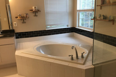 Example of a mid-sized classic master black and white tile and subway tile porcelain tile and white floor bathroom design in Baltimore with shaker cabinets, white cabinets, beige walls, an undermount sink and a hinged shower door