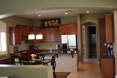Transitional kitchen photo in Sacramento with a double-bowl sink, medium tone wood cabinets, beige backsplash, stainless steel appliances and an island
