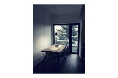Idee per una piccola sala da pranzo aperta verso la cucina minimal con pareti bianche, pavimento in gres porcellanato e pavimento marrone