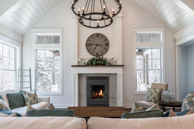 Inspiration for a large timeless dark wood floor, brown floor, vaulted ceiling and wall paneling living room remodel in Denver with white walls, a standard fireplace, a tile fireplace and no tv