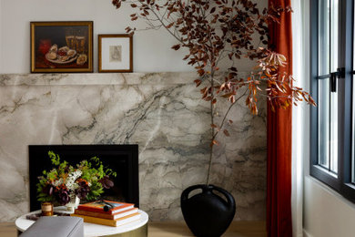 Foto de salón cerrado moderno de tamaño medio sin televisor con paredes blancas, suelo de madera clara, todas las chimeneas, marco de chimenea de piedra y suelo beige