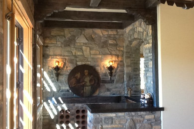 Example of a small tuscan u-shaped wet bar design in Los Angeles with no sink, quartz countertops, gray backsplash and stone tile backsplash