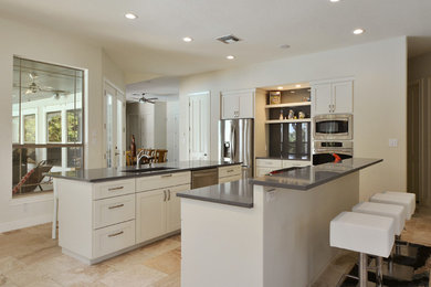 Inspiration for a large contemporary u-shaped open plan kitchen in Austin with an undermount sink, shaker cabinets, white cabinets, grey splashback, glass sheet splashback, stainless steel appliances, travertine floors, multiple islands and quartz benchtops.