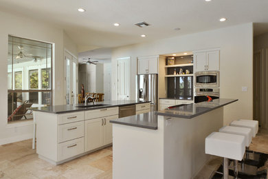 Open concept kitchen - large contemporary u-shaped travertine floor open concept kitchen idea in Austin with an undermount sink, shaker cabinets, white cabinets, gray backsplash, glass sheet backsplash, stainless steel appliances, two islands and quartz countertops