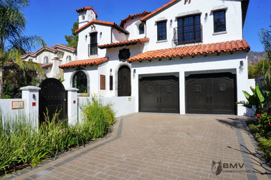 Large white two-story stucco exterior home idea in Los Angeles with a tile roof and a red roof