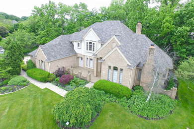 Large traditional beige two-story mixed siding exterior home idea in Columbus with a hip roof