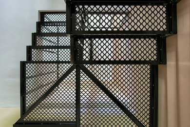Ejemplo de escalera suspendida actual con escalones de metal y contrahuellas de madera