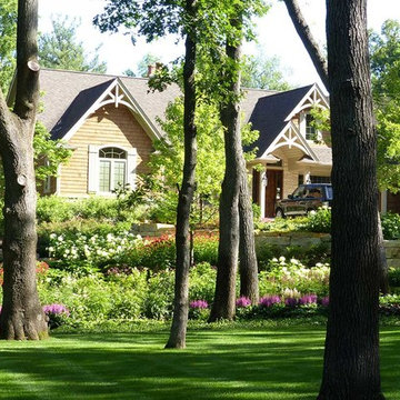 Woodland craftsman with stone retaining wall and lush plantings
