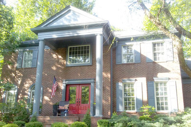 Huge elegant blue two-story brick exterior home photo in Cincinnati with a metal roof