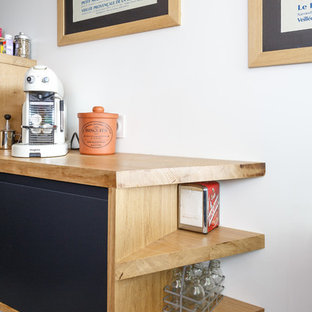 Пример оригинального дизайна интерьера: маленькая отдельная, угловая кухня в скандинавском стиле с накладной раковиной, плоскими фасадами, черными фасадами, столешницей из дерева, белым фартуком, фартуком из керамической плитки, техникой из нержавеющей стали, полом из терраццо, разноцветным полом и коричневой столешницей без острова