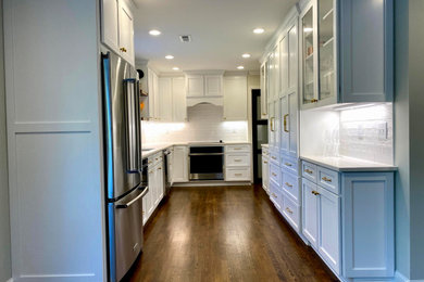 Design ideas for a small transitional u-shaped eat-in kitchen in Raleigh with a single-bowl sink, shaker cabinets, white cabinets, quartz benchtops, white splashback, ceramic splashback, stainless steel appliances, dark hardwood floors, no island, brown floor and white benchtop.