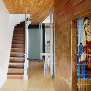 Ispirazione per un piccolo ingresso moderno con pareti bianche, pavimento in bambù e una porta a due ante