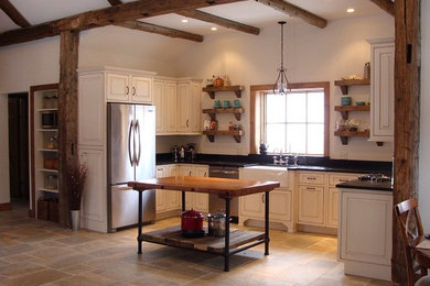 Design ideas for a traditional u-shaped eat-in kitchen in Boston with a farmhouse sink, raised-panel cabinets, white cabinets, granite benchtops and white appliances.