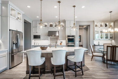 Kitchen - mid-sized contemporary u-shaped kitchen idea in Phoenix with white cabinets, quartzite countertops and an island