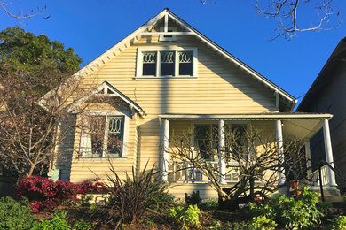 Mid-sized country one-storey yellow house exterior in San Francisco with wood siding and a gable roof.
