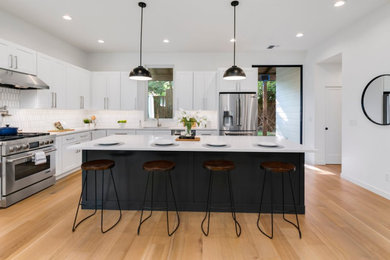Inspiration for a large modern l-shaped light wood floor eat-in kitchen remodel in Seattle with shaker cabinets, white cabinets, granite countertops, white backsplash, mosaic tile backsplash, stainless steel appliances, an island and white countertops