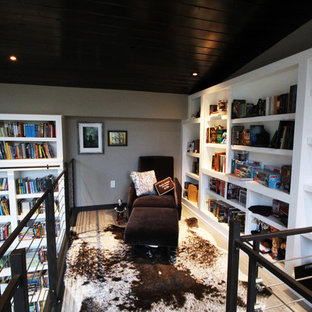 Large modern home office and library in Other with a reading nook, white walls, concrete flooring, a two-sided fireplace, a wooden fireplace surround and a freestanding desk.