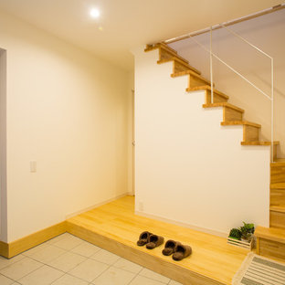 他の地域の引き戸カントリー風おしゃれな玄関 (白い壁、濃色木目調のドア、グレーの床) の写真