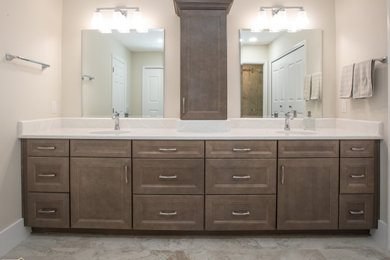 Mid-sized transitional master beige tile and porcelain tile porcelain tile, multicolored floor and double-sink alcove shower photo in Orlando with recessed-panel cabinets, brown cabinets, an undermount sink, quartz countertops, beige countertops and a built-in vanity