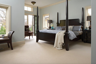 Photo of a large contemporary master bedroom in Providence with blue walls, carpet and beige floor.