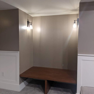 Basement with a banquette, beams, wainscot and bookcases
