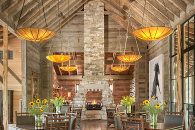 Example of a mountain style great room design in Austin with a two-sided fireplace and a stone fireplace