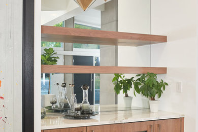Example of a large minimalist galley light wood floor and white floor eat-in kitchen design in Los Angeles with flat-panel cabinets, medium tone wood cabinets, quartz countertops, mirror backsplash, stainless steel appliances, an island and white countertops