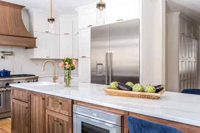 Eat-in kitchen - large country galley laminate floor and brown floor eat-in kitchen idea in Los Angeles with an undermount sink, shaker cabinets, brown cabinets, quartz countertops, white backsplash, quartz backsplash, stainless steel appliances, an island and white countertops