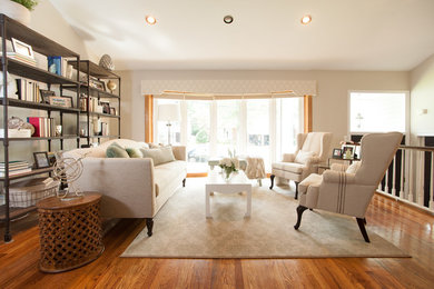 Example of a mid-sized transitional open concept light wood floor living room design in New York with gray walls, no fireplace and no tv