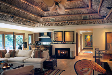 Large island style open concept light wood floor living room photo in Miami with yellow walls, a standard fireplace, a metal fireplace and no tv