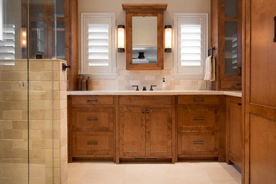 Inspiration for a contemporary beige tile and ceramic tile ceramic tile corner shower remodel in Other with beaded inset cabinets, medium tone wood cabinets, beige walls and tile countertops