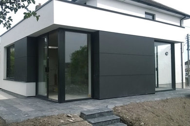 Design ideas for a white contemporary house exterior in Cork with a flat roof.