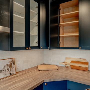 Navy Shaker Cabinetry with Butcher Block Countertops and Glass-Front Uppers