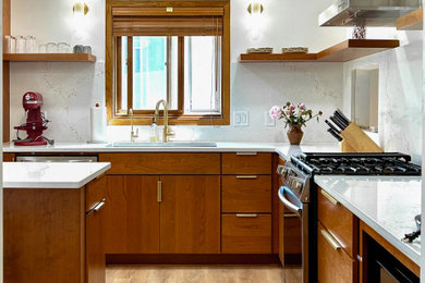 Eat-in kitchen - mid-sized 1950s l-shaped vinyl floor and brown floor eat-in kitchen idea in Minneapolis with an undermount sink, flat-panel cabinets, medium tone wood cabinets, quartz countertops, beige backsplash, quartz backsplash, stainless steel appliances, an island and beige countertops