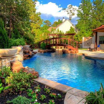 Natural Pool with rock waterfall, bridge, spa, and pergola