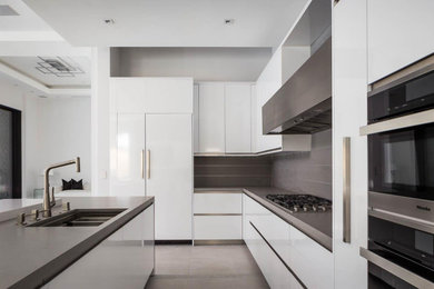 Photo of a large modern eat-in kitchen in Other with a double-bowl sink, flat-panel cabinets, white cabinets, solid surface benchtops, grey splashback, porcelain splashback, stainless steel appliances, porcelain floors, with island, grey floor and grey benchtop.